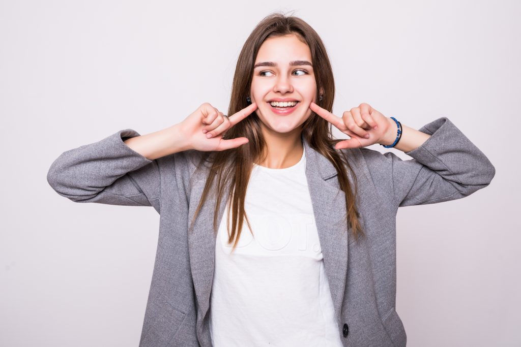 Woman showing her perfect straight white teeth.